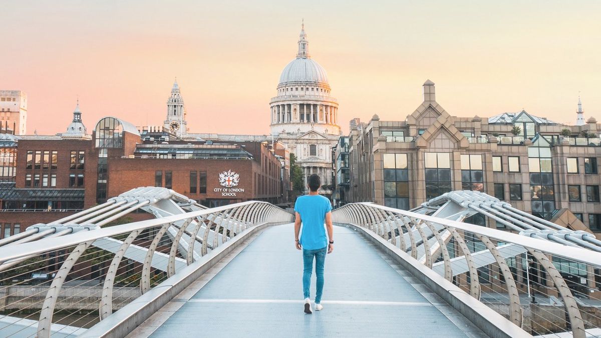 man walks on bridge in london, england