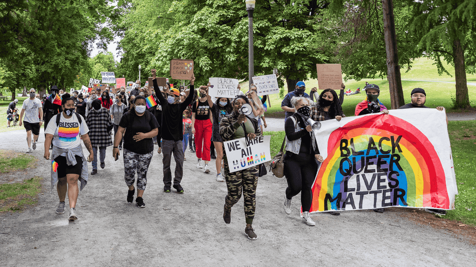 marchers hold signs that read black queer lives matter