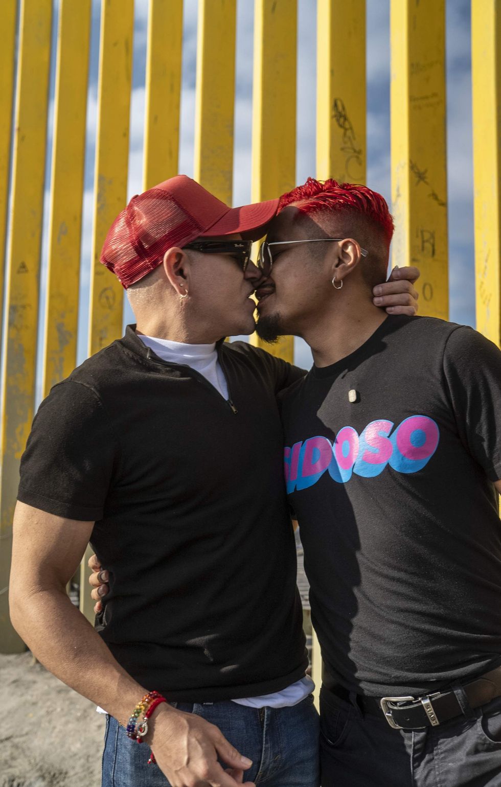 Two men kiss in front of U.S.-Mexico border