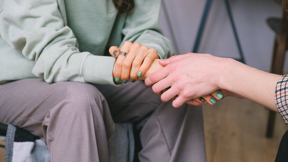 woman holding hands with another person